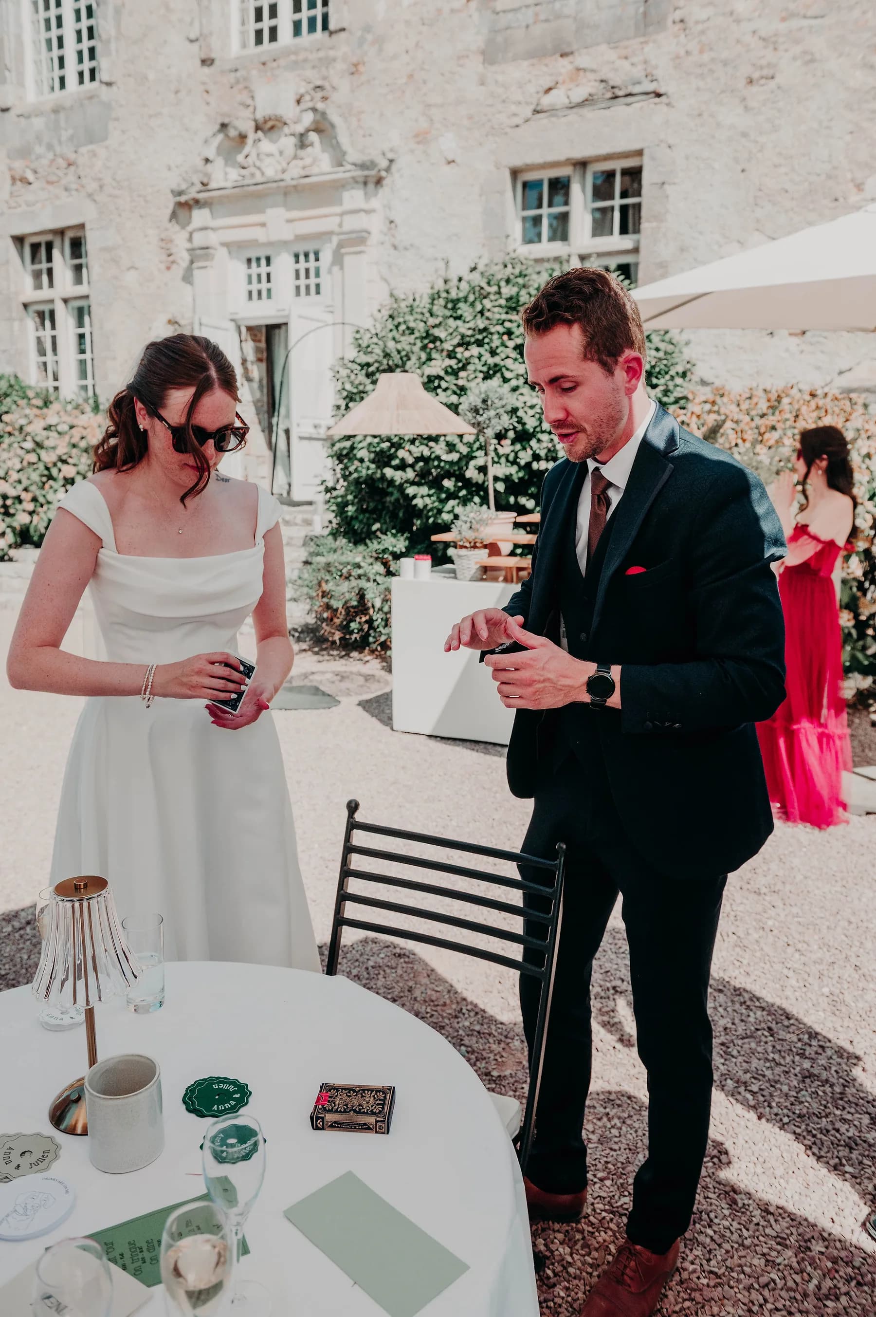 Une mariée observe un tour de cartes pendant le vin d'honneur